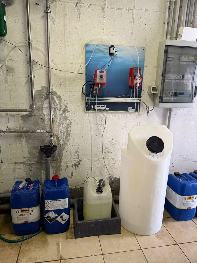 Pompe dosatrici e fusti di additivi chimici in una sala dosaggio
